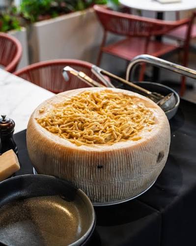 Pasta finished inside a wheel of pecorino cheese