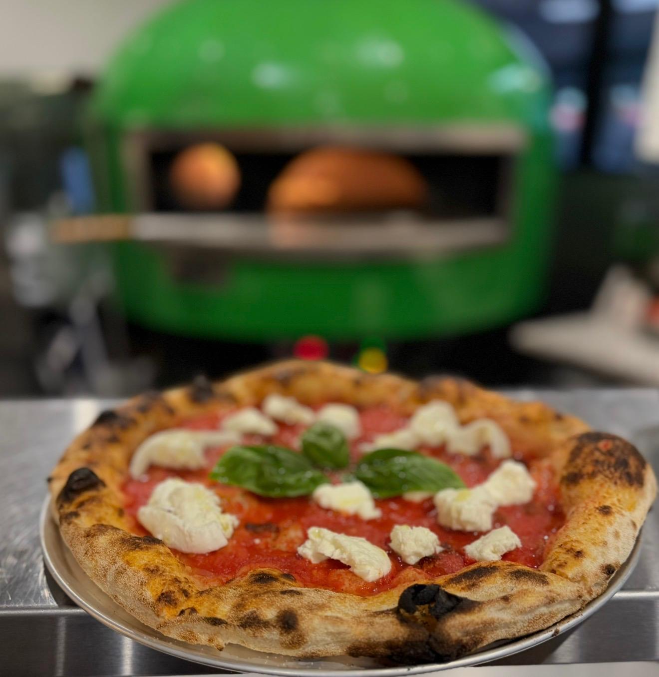 Hands shaping a fresh pizza base